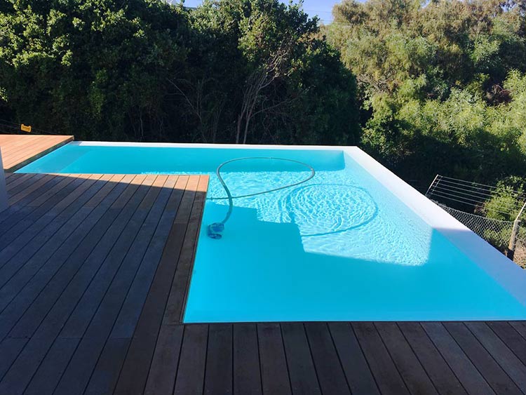White fibreglass swimming pool with rim-flow.